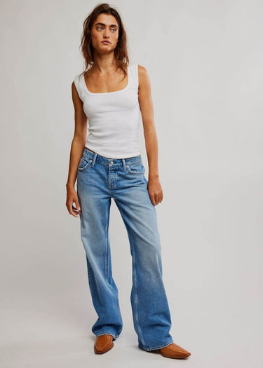 Frau trägt Tennessee Low Rise Boyfriend Jeans für Frauen mit einem weißen Tanktop und stilvollen Schuhen.