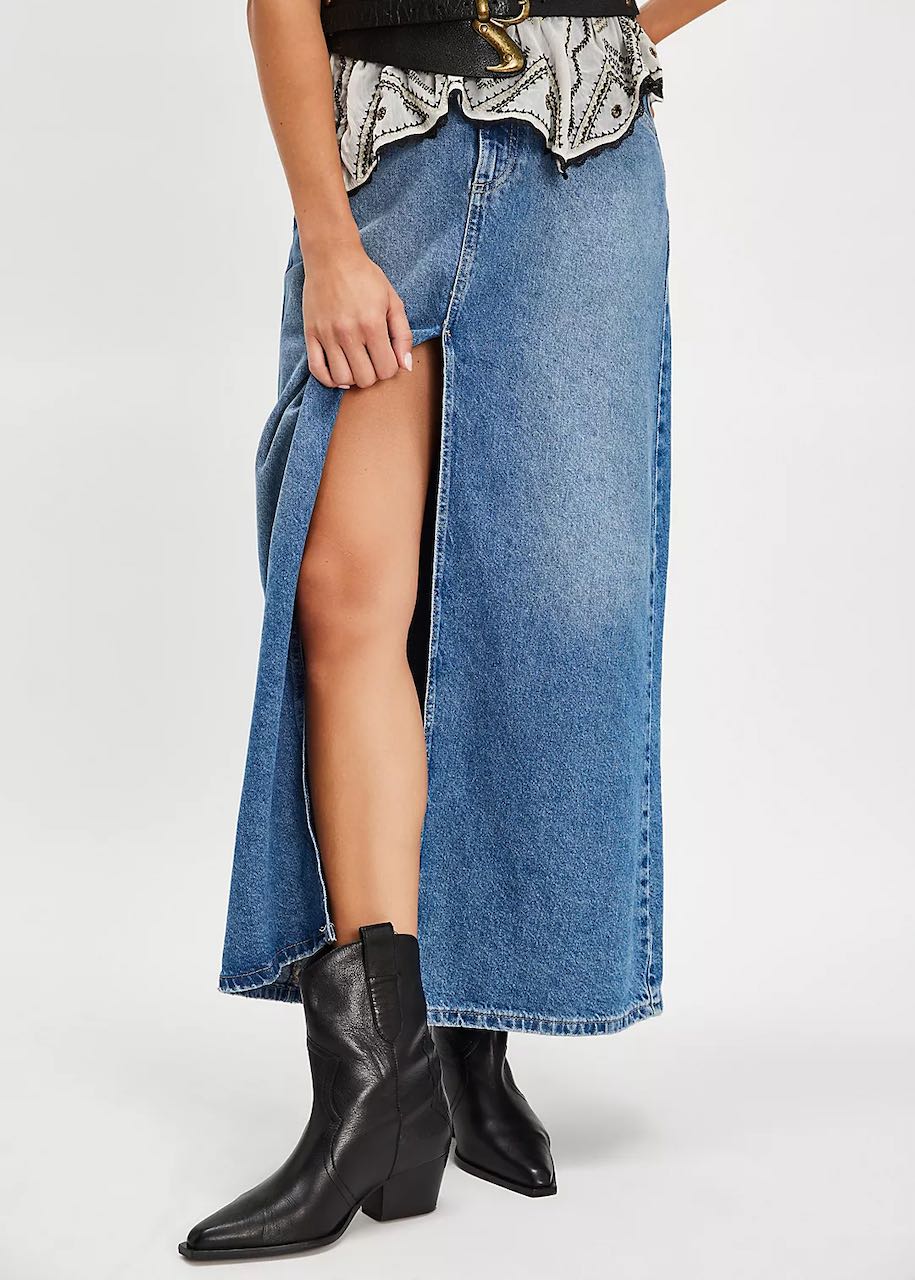 A woman wearing a denim maxi skirt paired with stylish Cowboy Boots Women's, showcasing a chic western look.